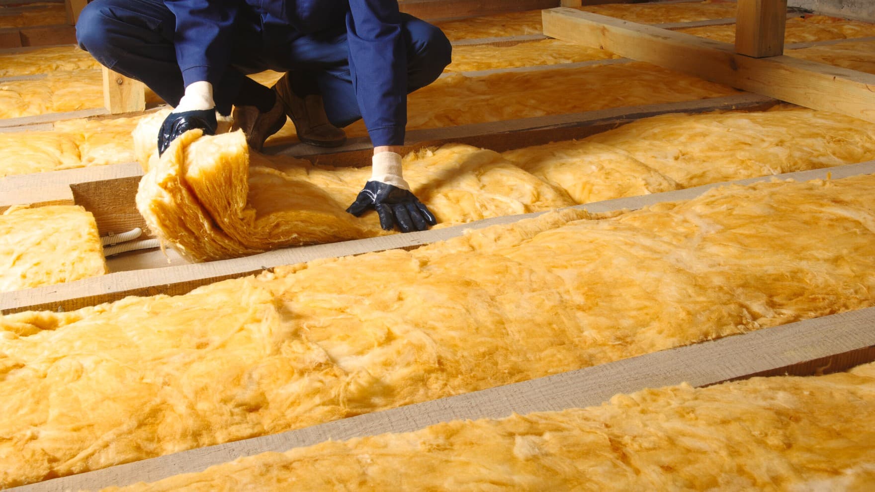 man met persoonlijke beschermingsmiddelen die vloerverwarming installeert