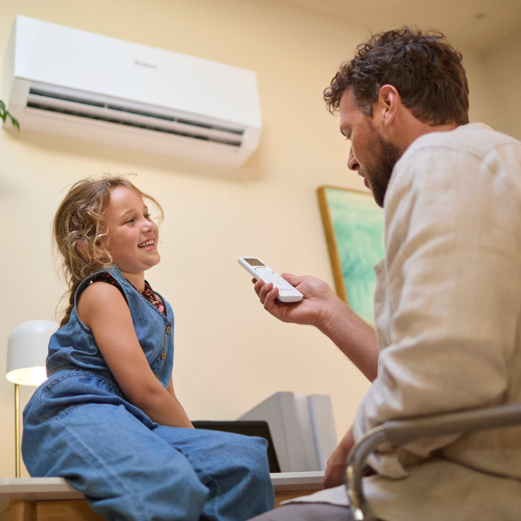 Man en kind met een airco van Vaillant en een afstandsbediening