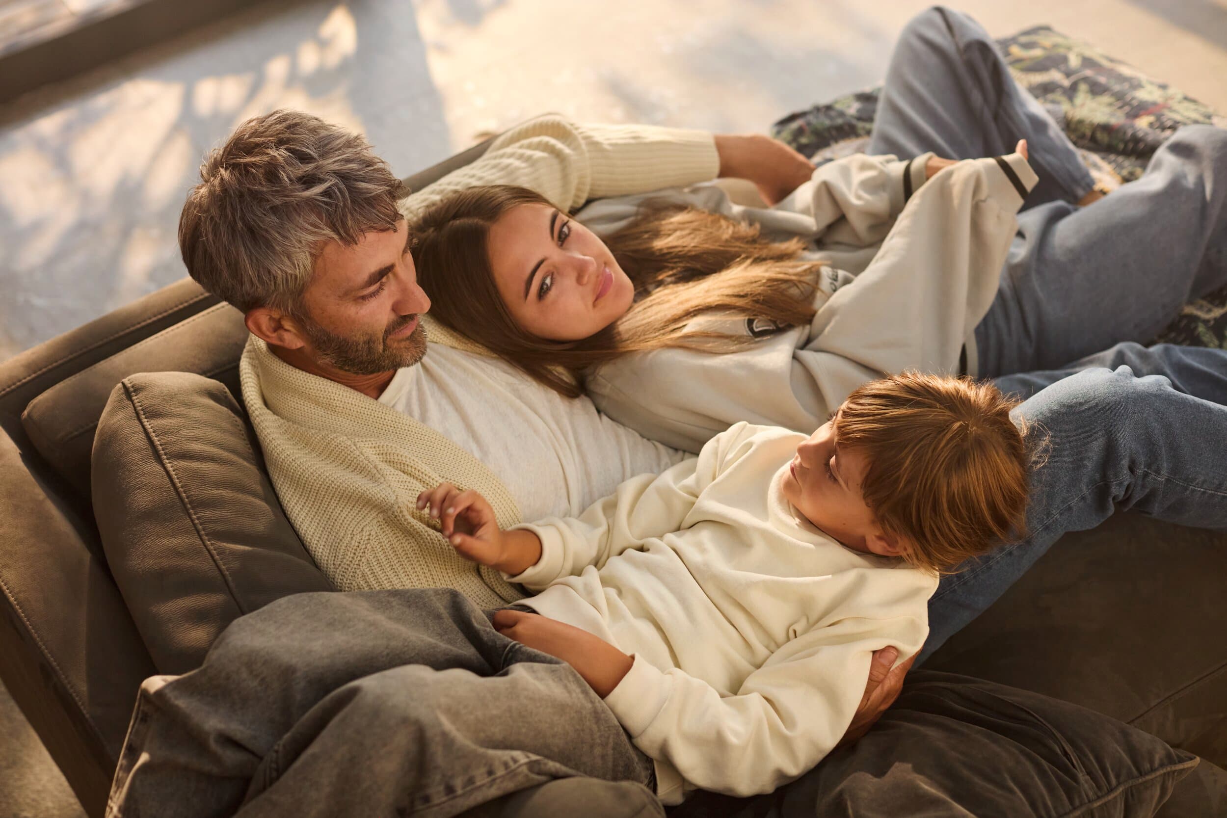 Vader zit lekker ontspannen met de kinderen op de bank