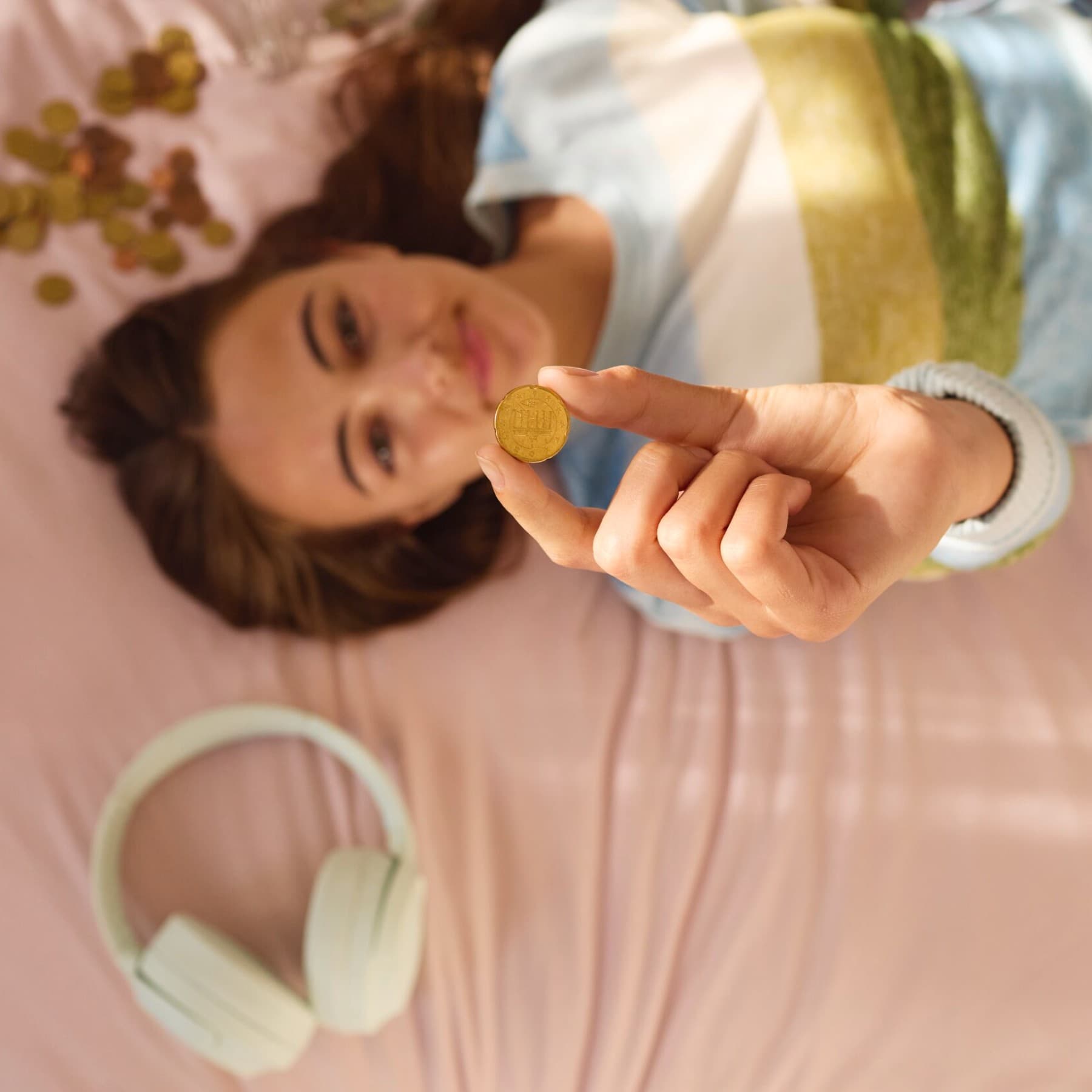 Meisje telt geld op bed.