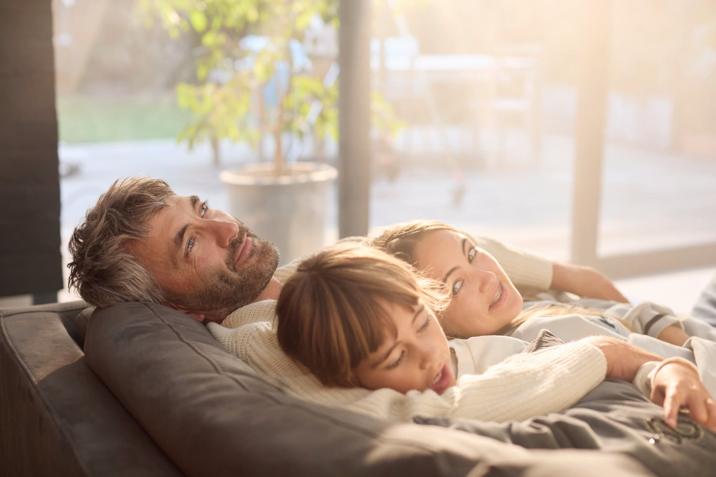 Vader zit lekker ontspannen met de kinderen op de bank