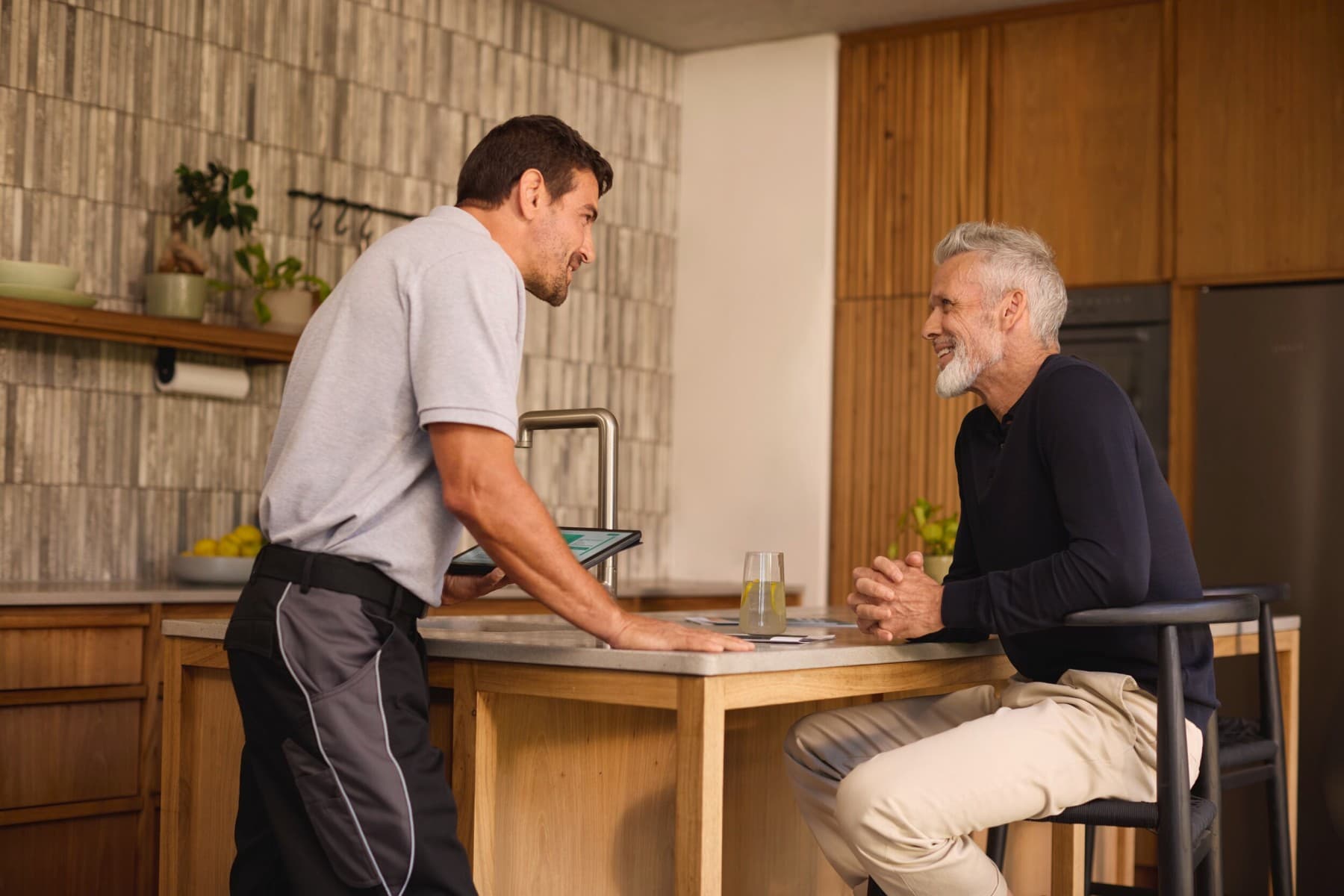 Een installateur en een eindklant die met elkaar praten over de mogelijkheden van een nieuw verwarmingssysteem.