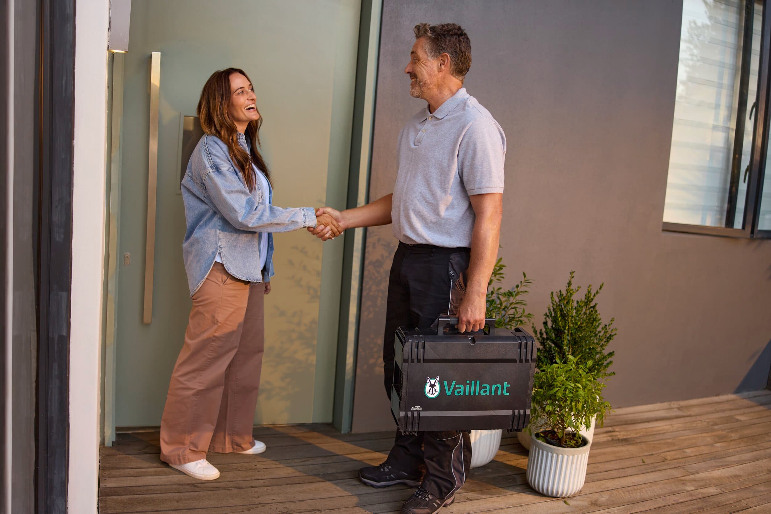 Vrouw schudt de hand van een Vaillant-servicemedewerker