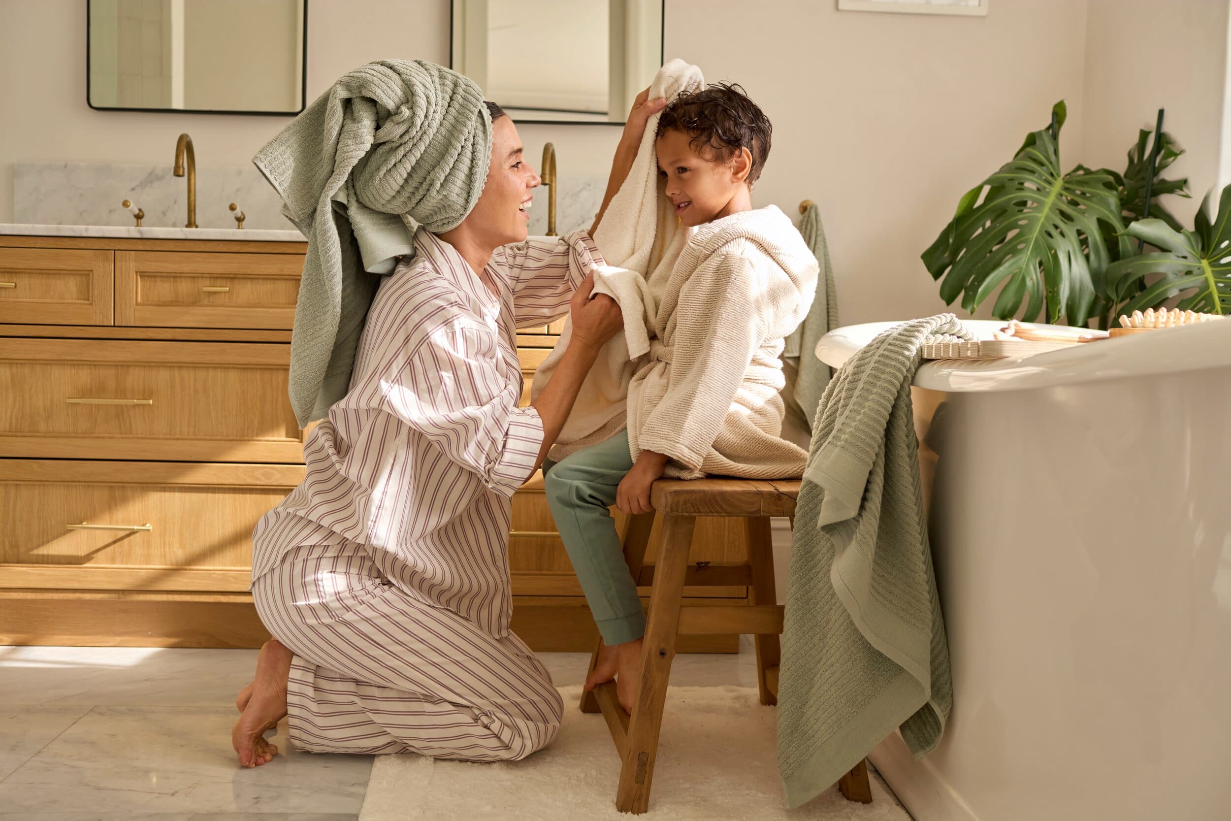Vrouw droogt het hoofdje van een kind in de badkamer