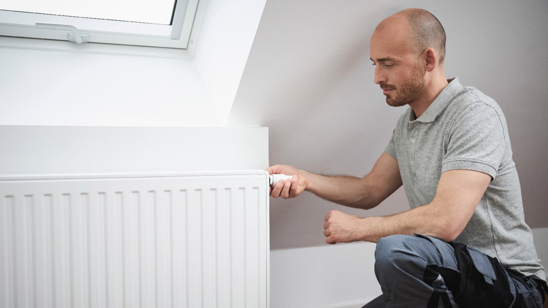 Man die de thermostaat op een radiator aanzet