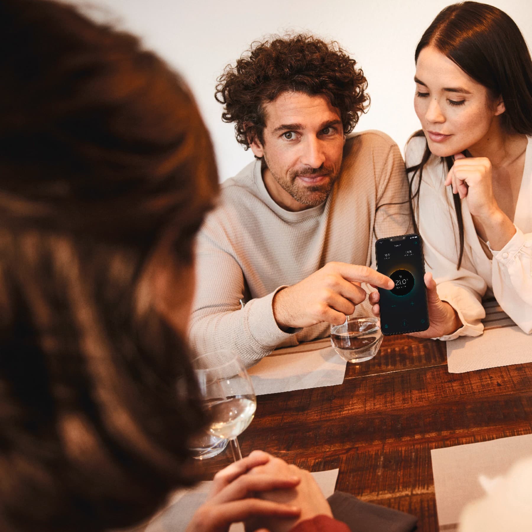 Mensen aan een tafel bekijken de myVaillant app
