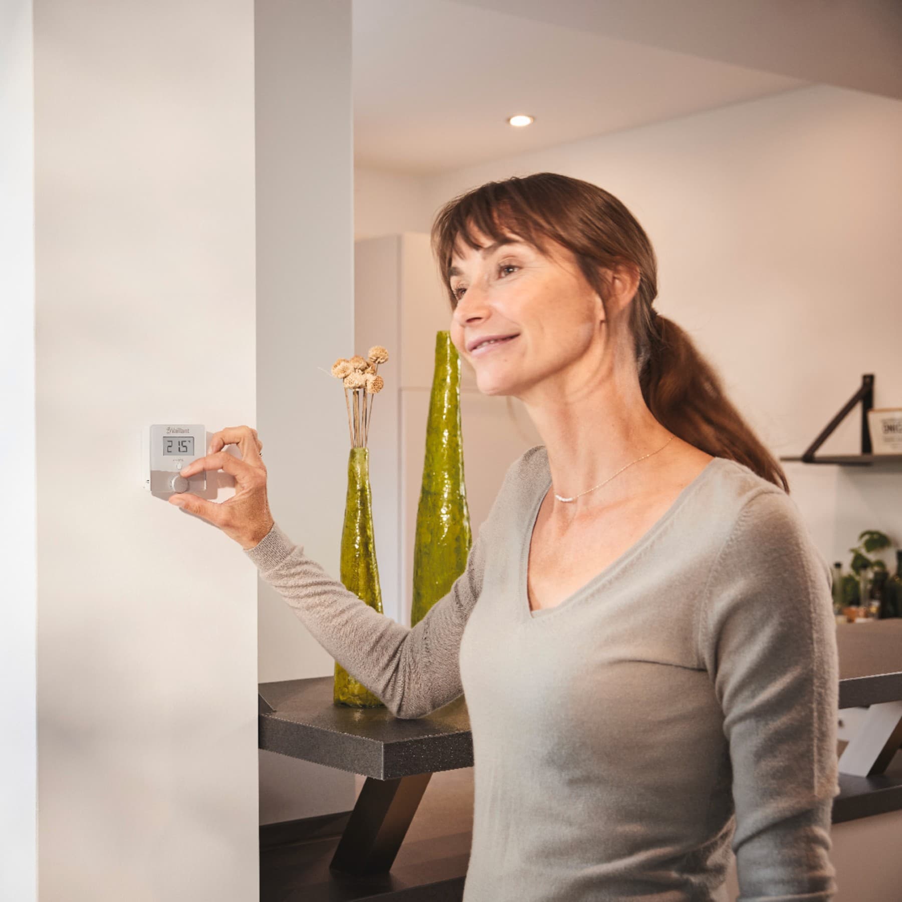 Vrouw die een thermostaat aan de muur aanzet