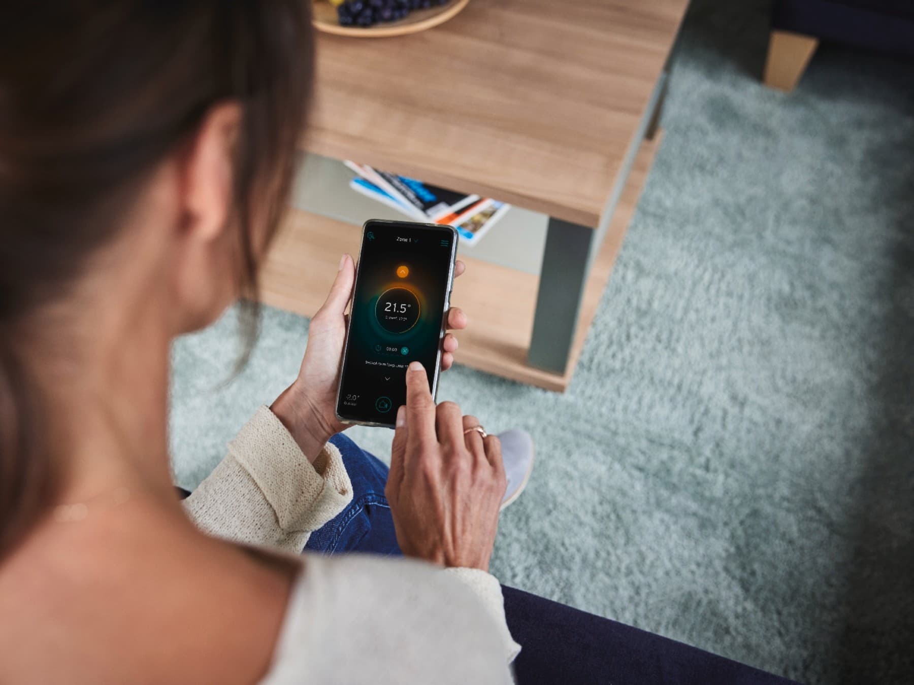 Vrouw die haar slimme systeem op haar telefoon aanpast.