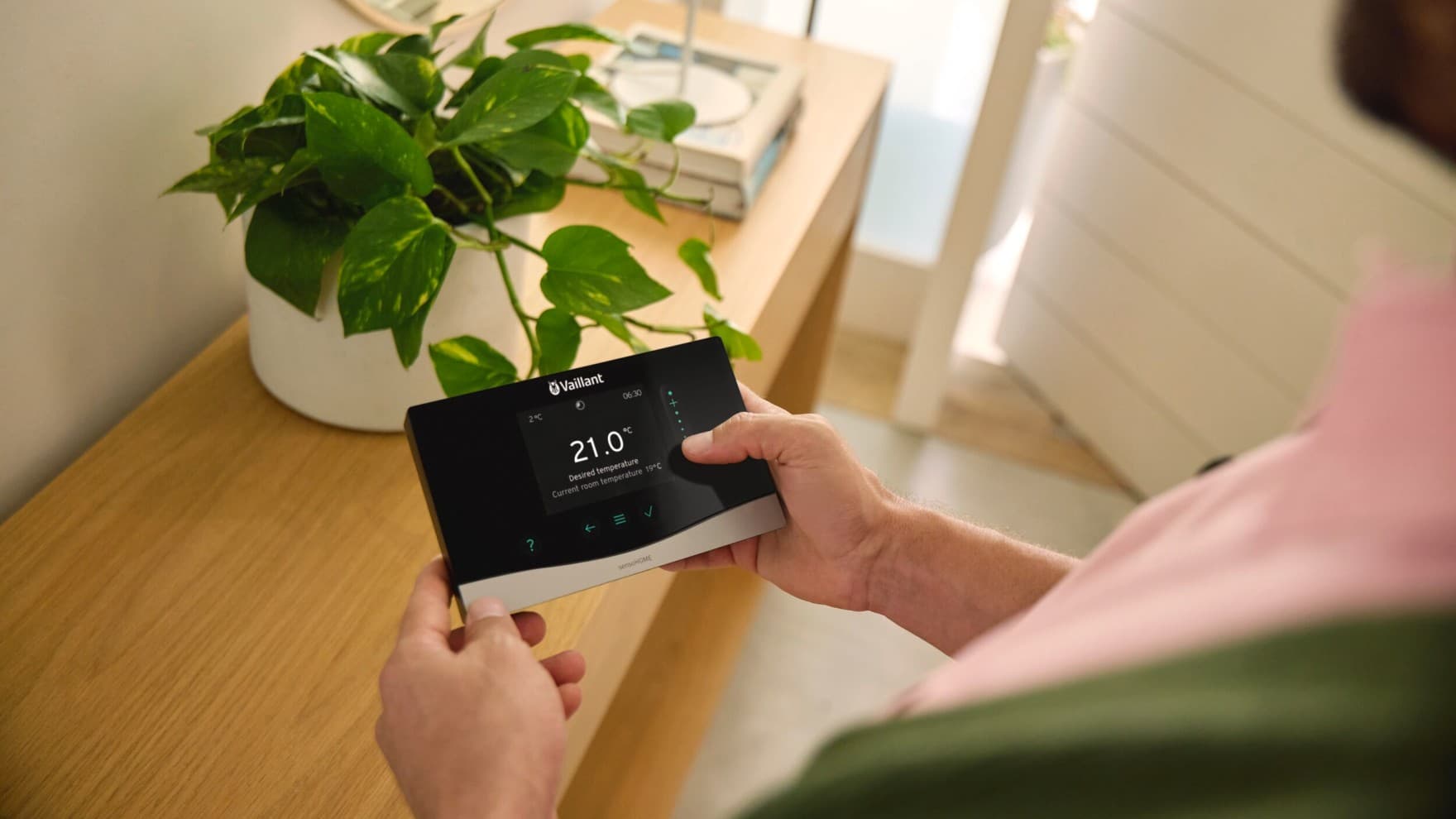 Man met een Vaillant-bedieningsunit in zijn hand