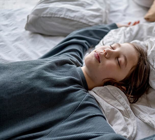 Een persoon die op een bed slaapt.