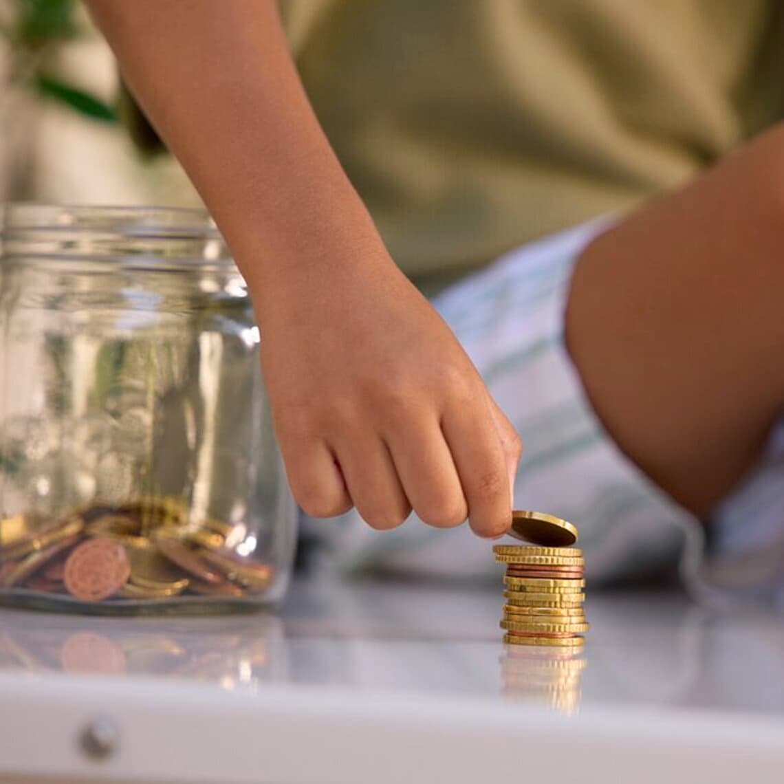 Kind telt munten terwijl het op een warmtepomp zit.