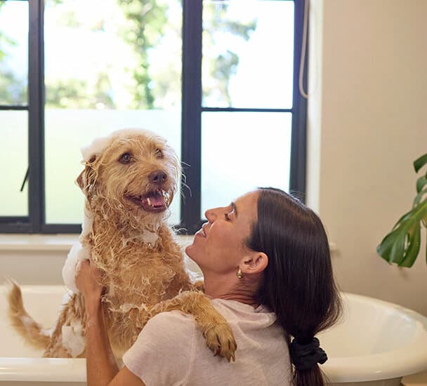 Vrouw wast hond in bad