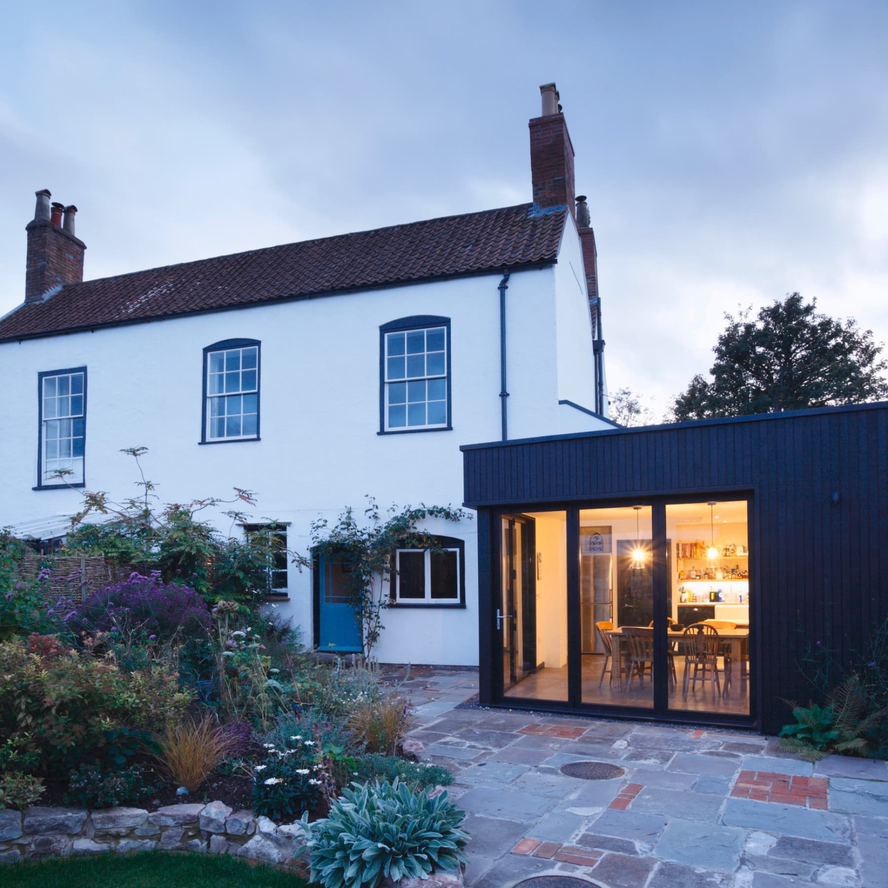 Huis in de schemering met verlichte aanbouw