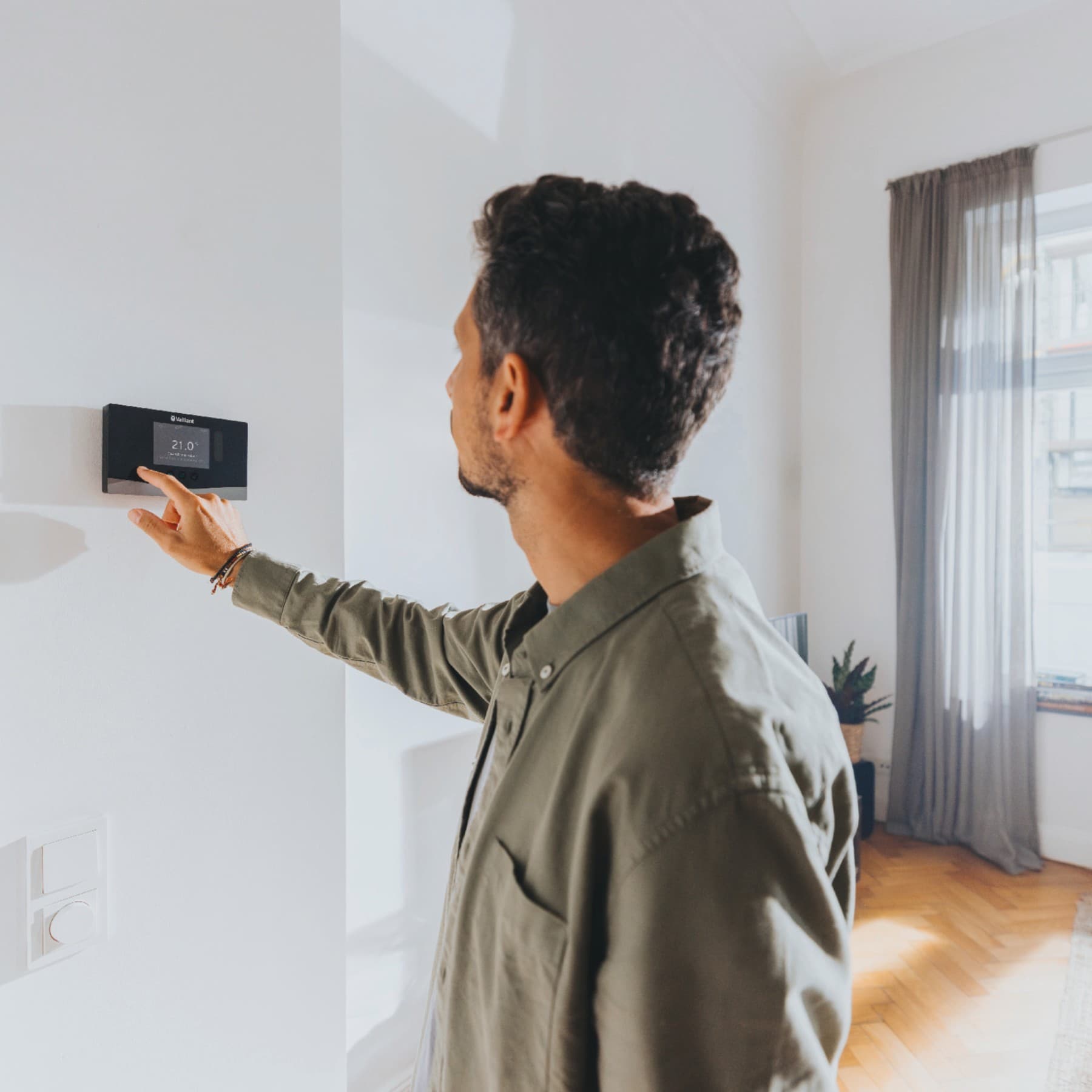 Een man die op een verwarmingsregelaar typt