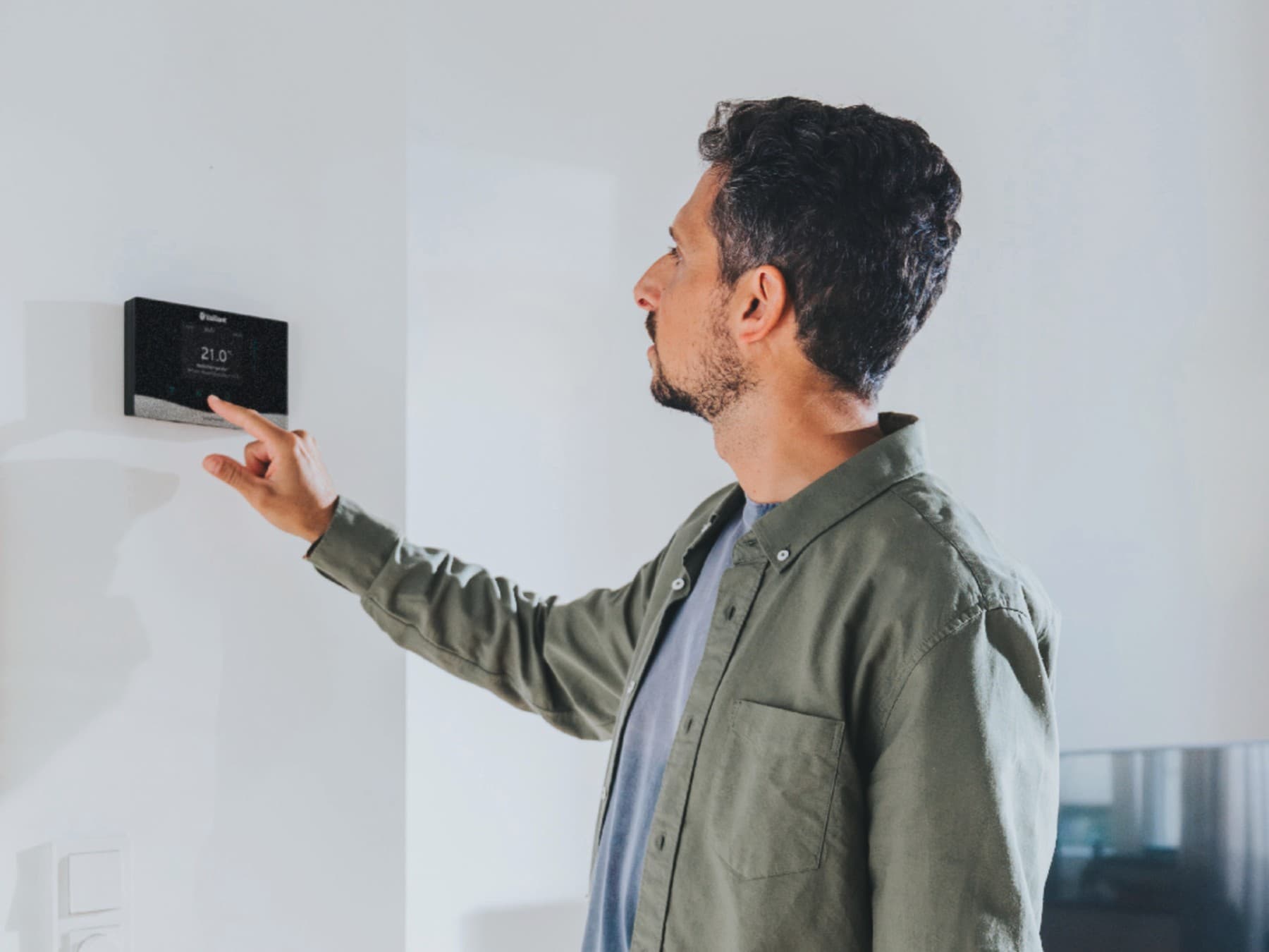 De mens gebruikt de verwarmingsregeling sensoCOMFORT