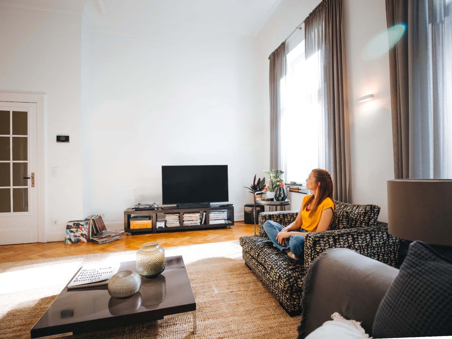 Vrouw zit op haar bank en geniet van de rust en stilte bij de perfecte temperatuur.