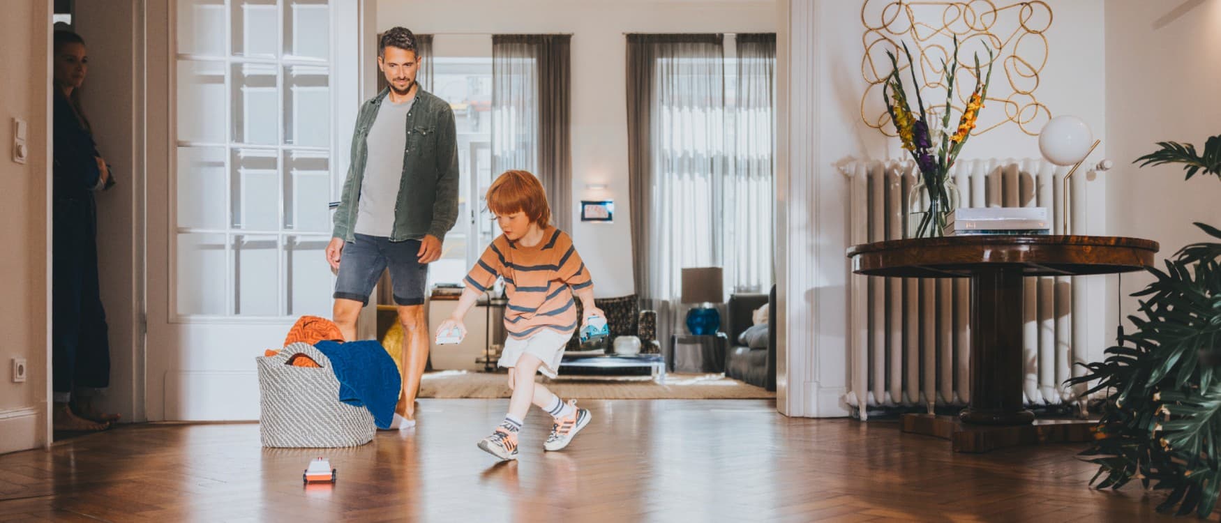 Vader kijkt toe hoe zijn zoon in de woonkamer speelt.