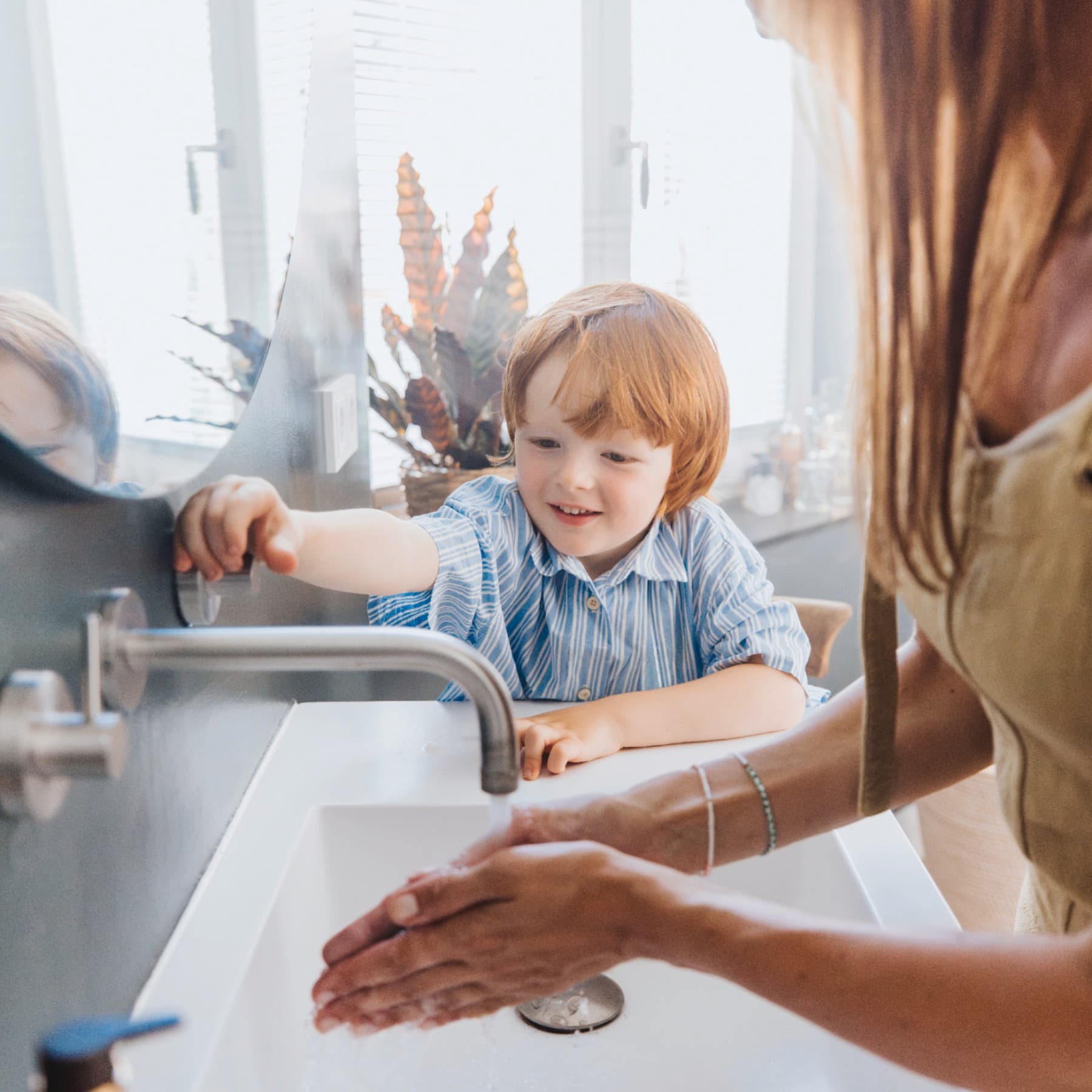 Een jongen en zijn moeder wassen hun handen
