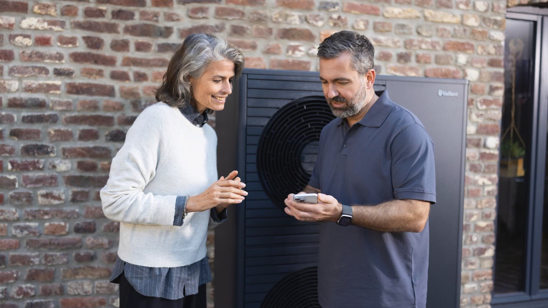 Installateur en huiseigenaar kijken naar smartphone