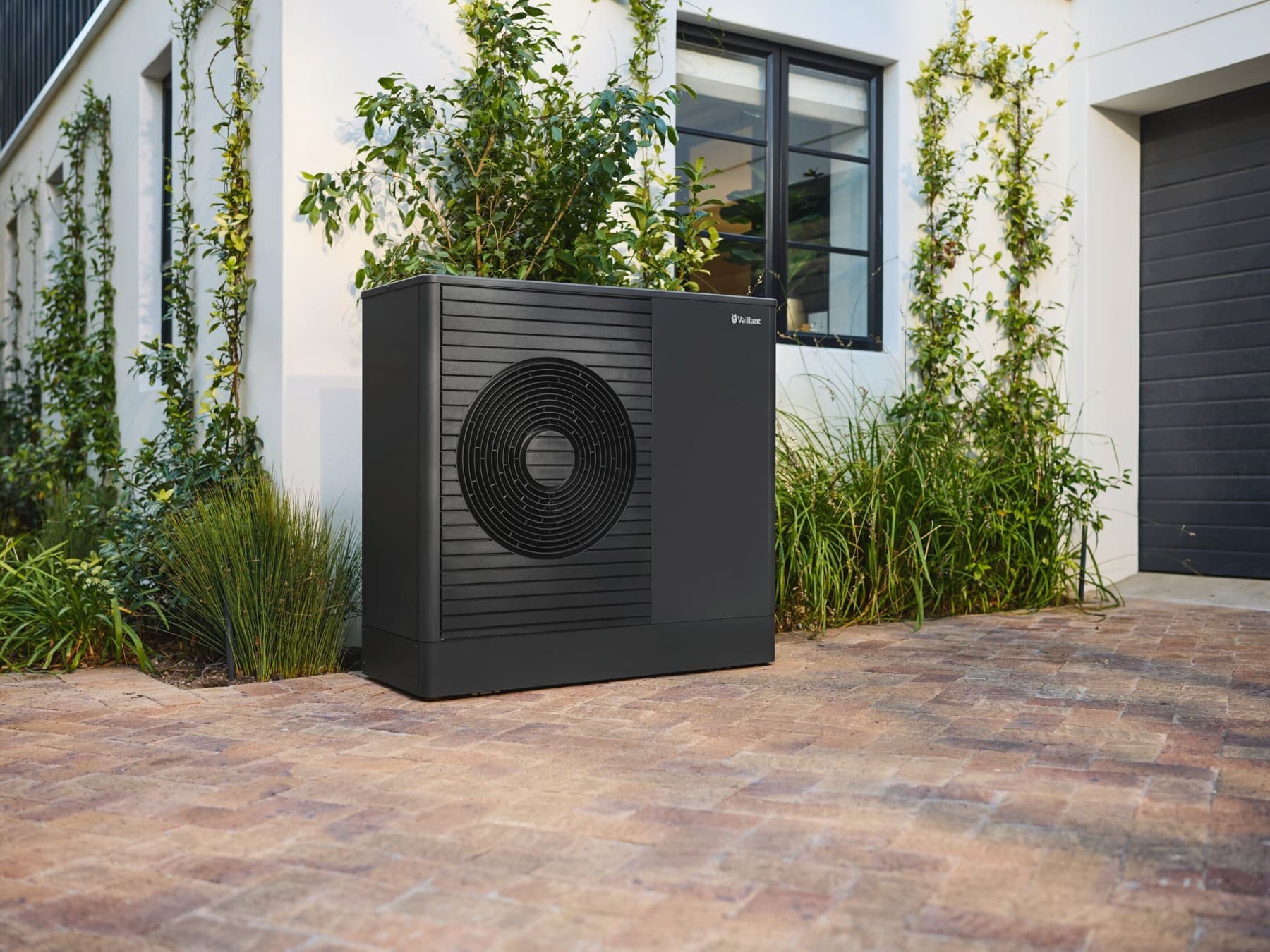 Antraciet warmtepomp aan de voorkant van het huis