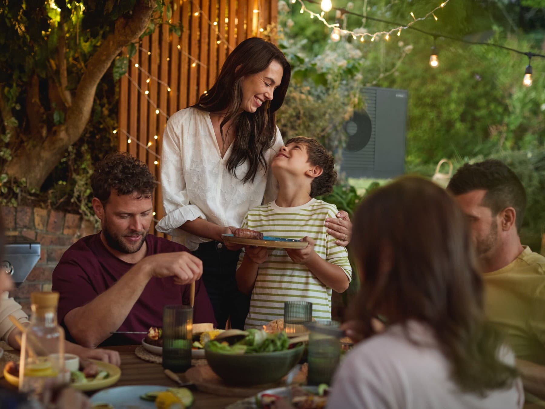 Familie geniet van een barbecue in de tuin met vrienden