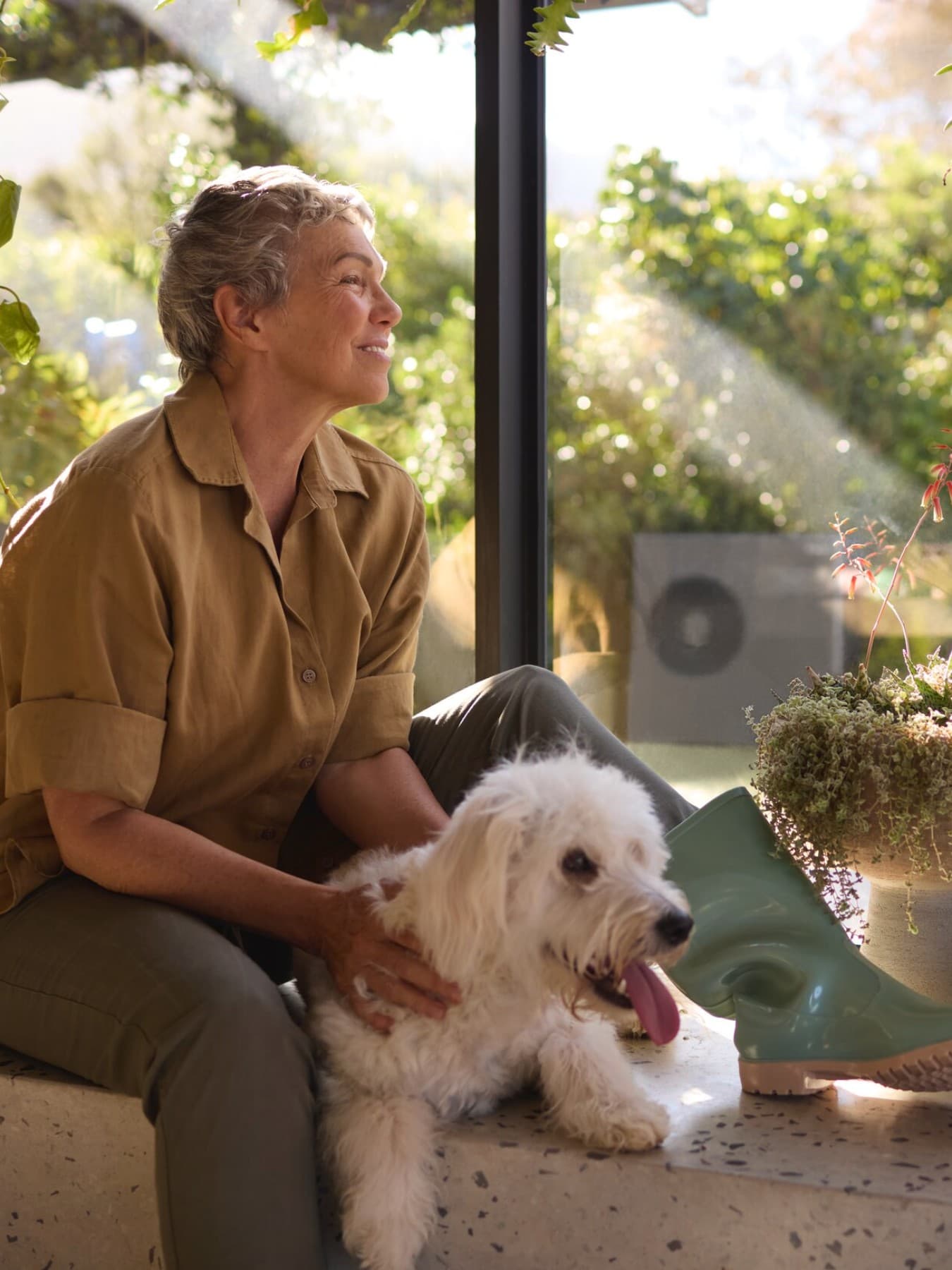 Vaillant warmtepomp aroTHERM plus in de tuin en dame zittend op de grond