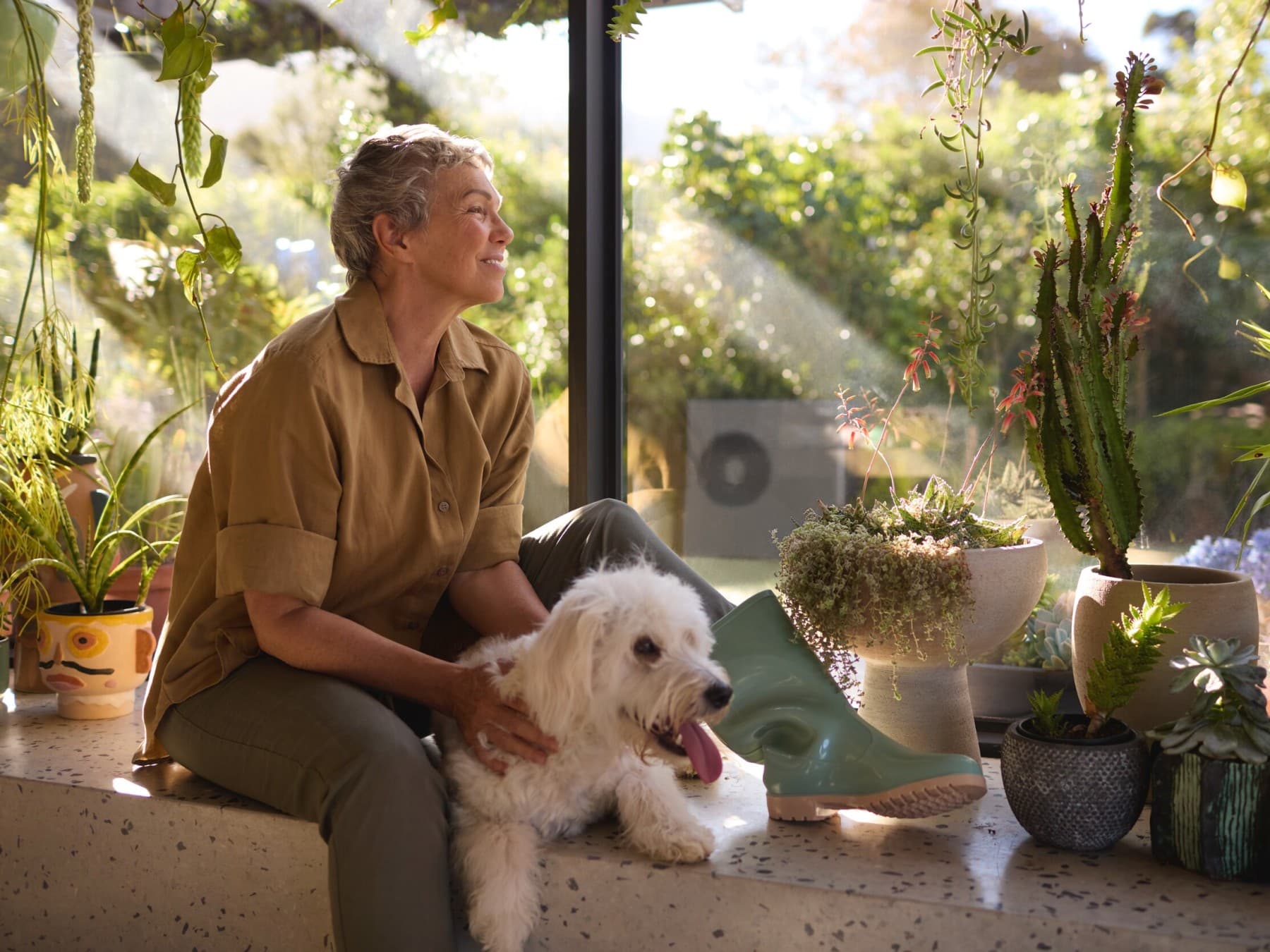 Vrouw zit met haar hond bij het raam