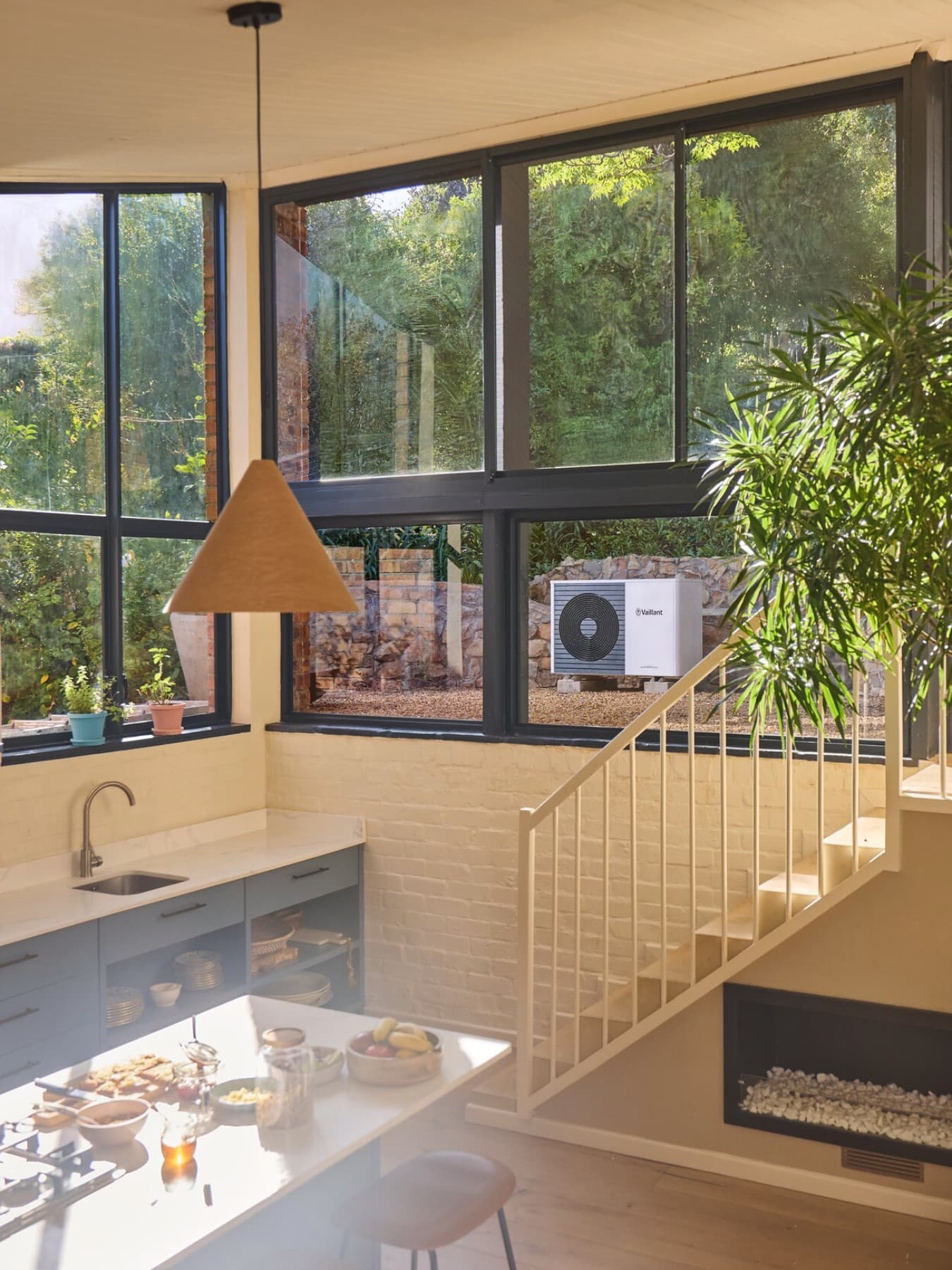 Vaillant-warmtepomp in de tuin zichtbaar door het raam