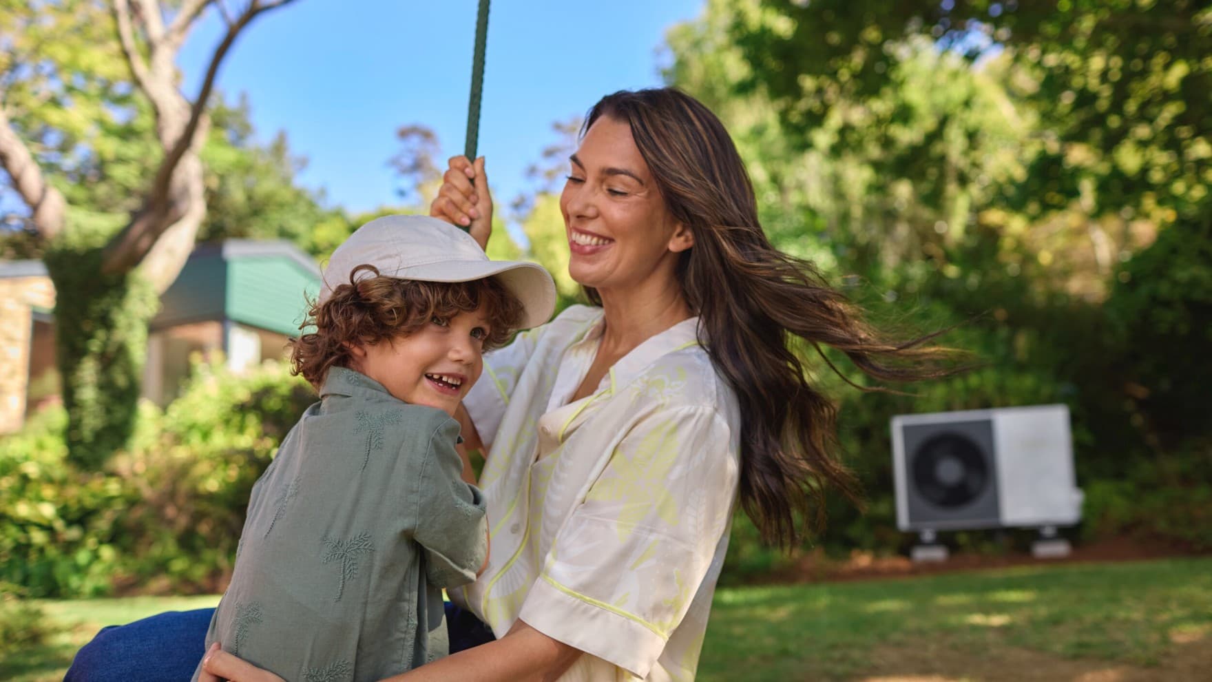 Moeder en zoon in de tuin voor hun warmtepomp