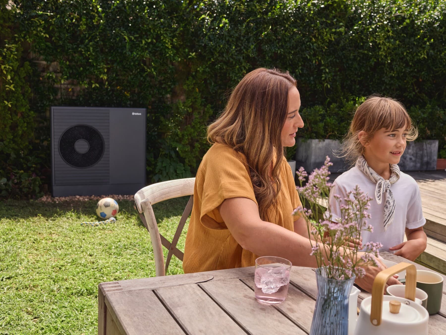 Vaillant-warmtepomp in een tuin met vrouw en kind