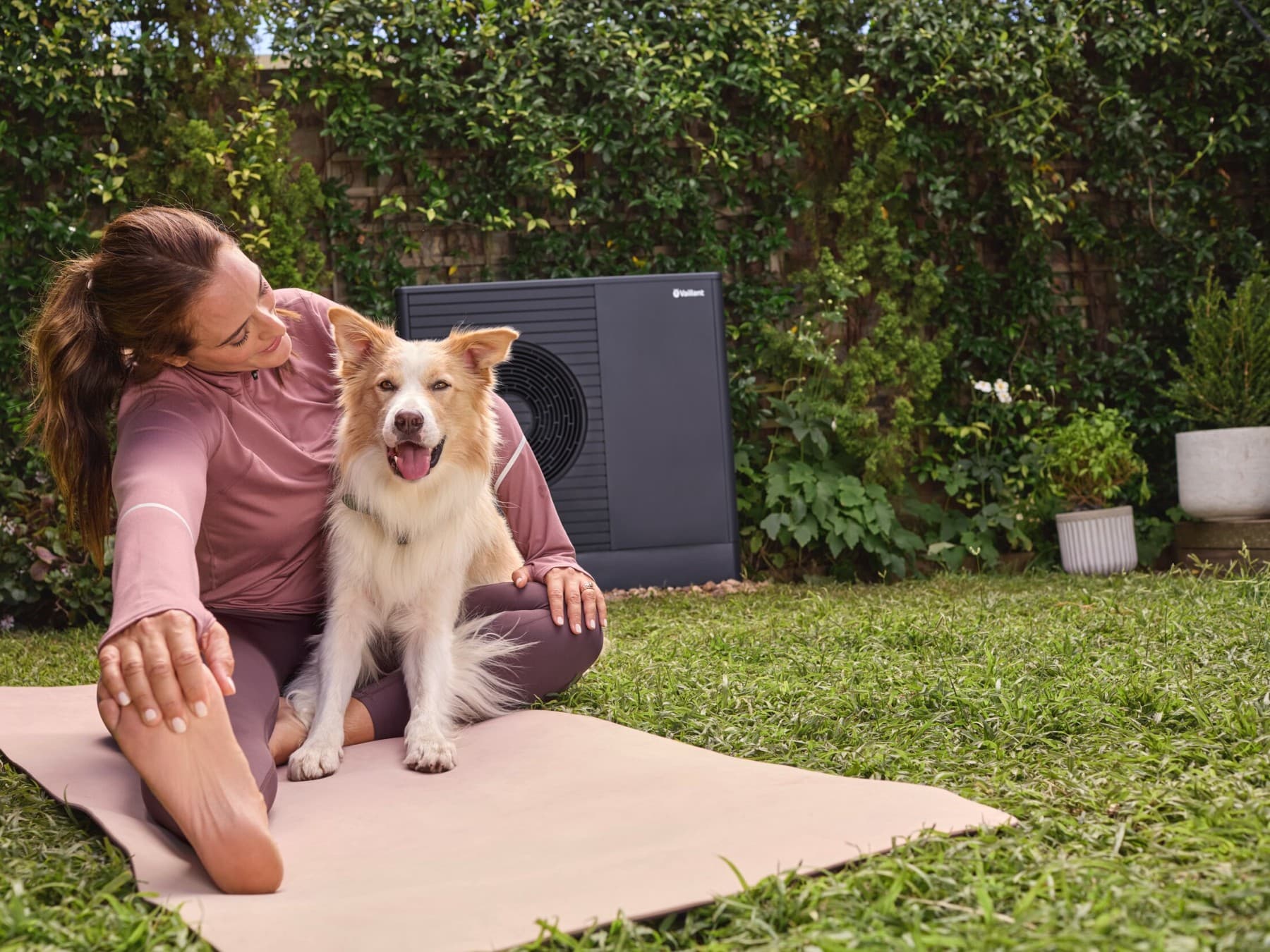 Vrouw en hond dichtbij een warmtepomp