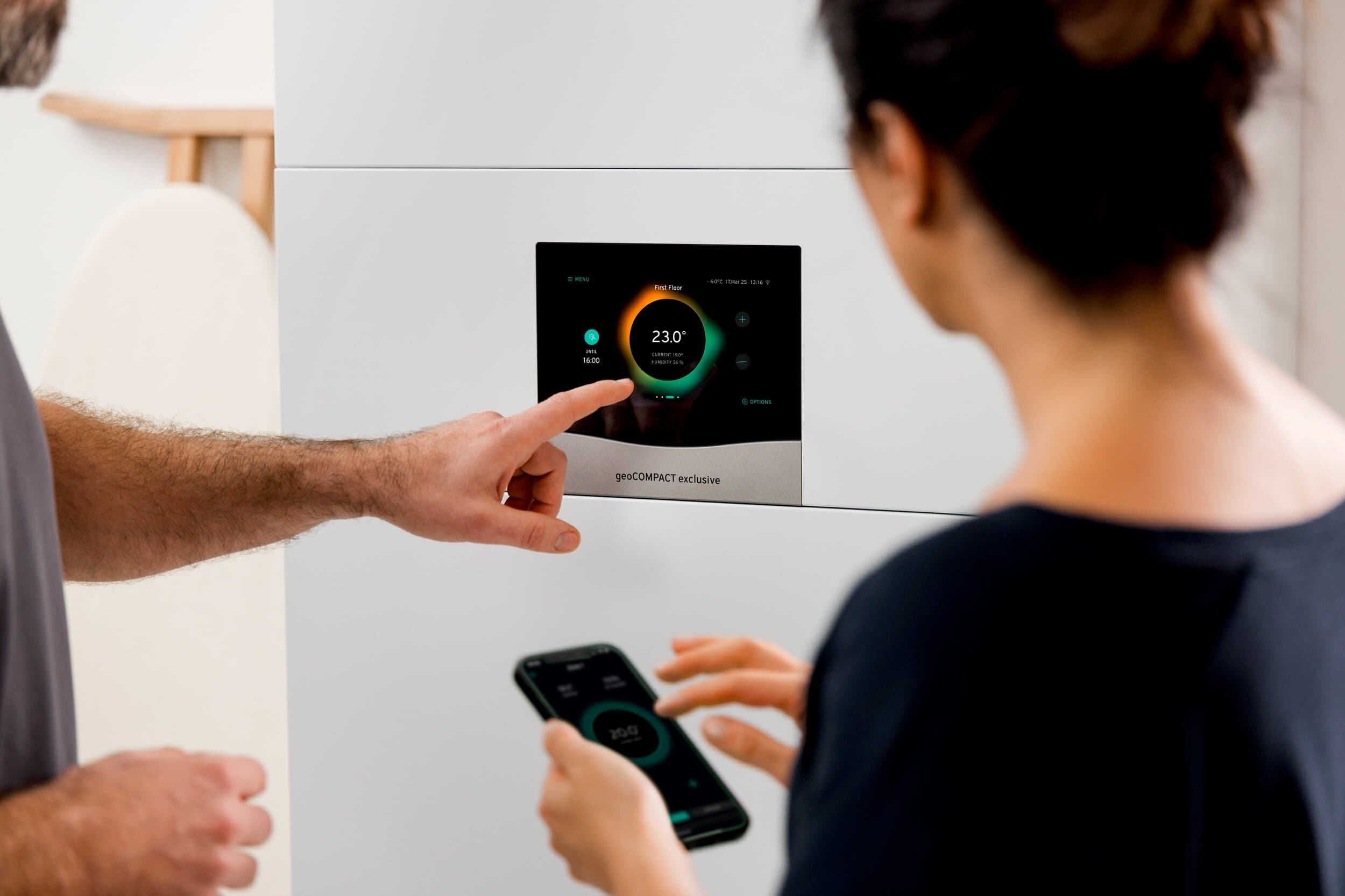 Iemand wijst naar het display van een warmtepomp.