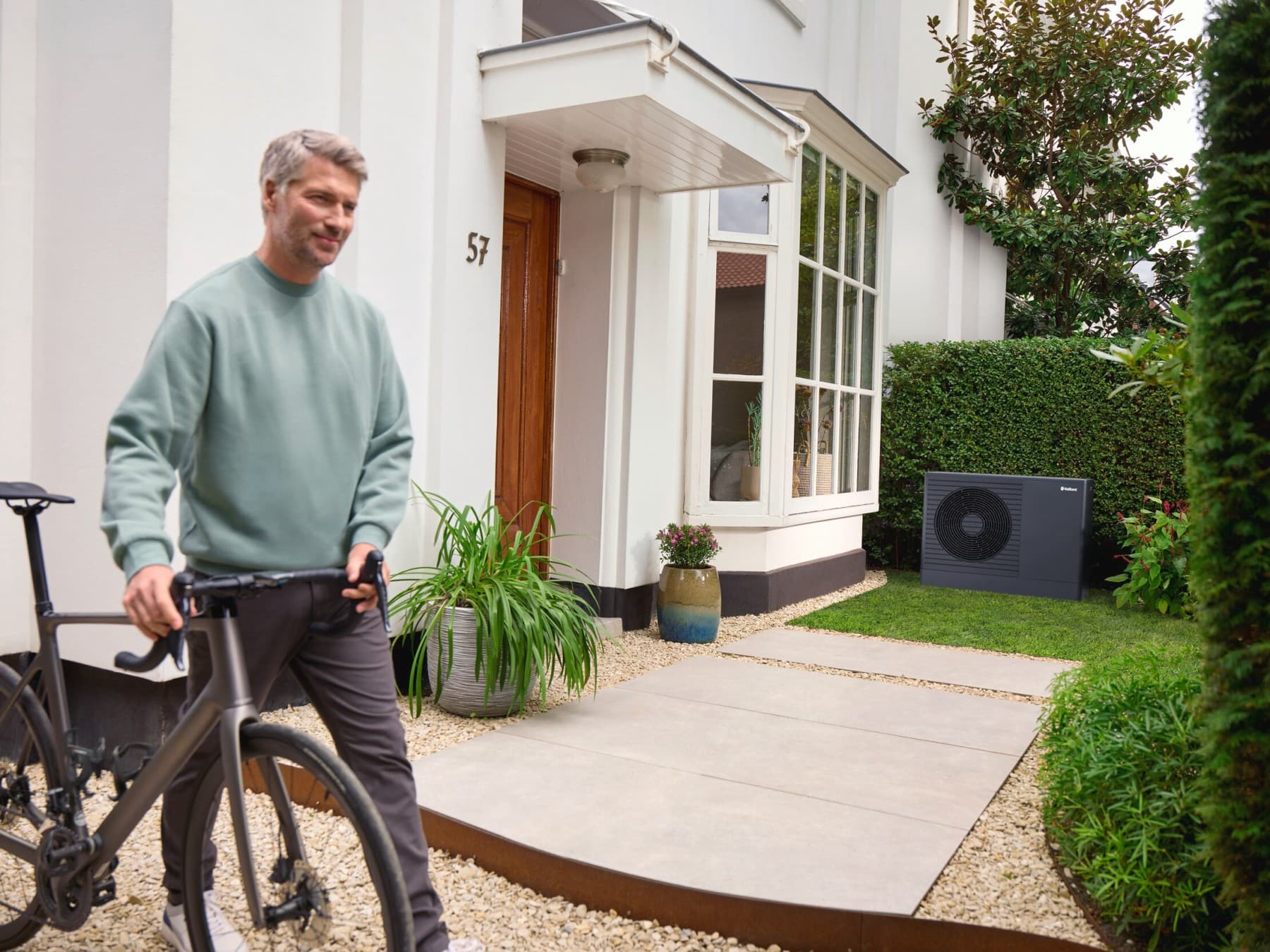 aroTHERM pro in een tuin met een meneer en fiets