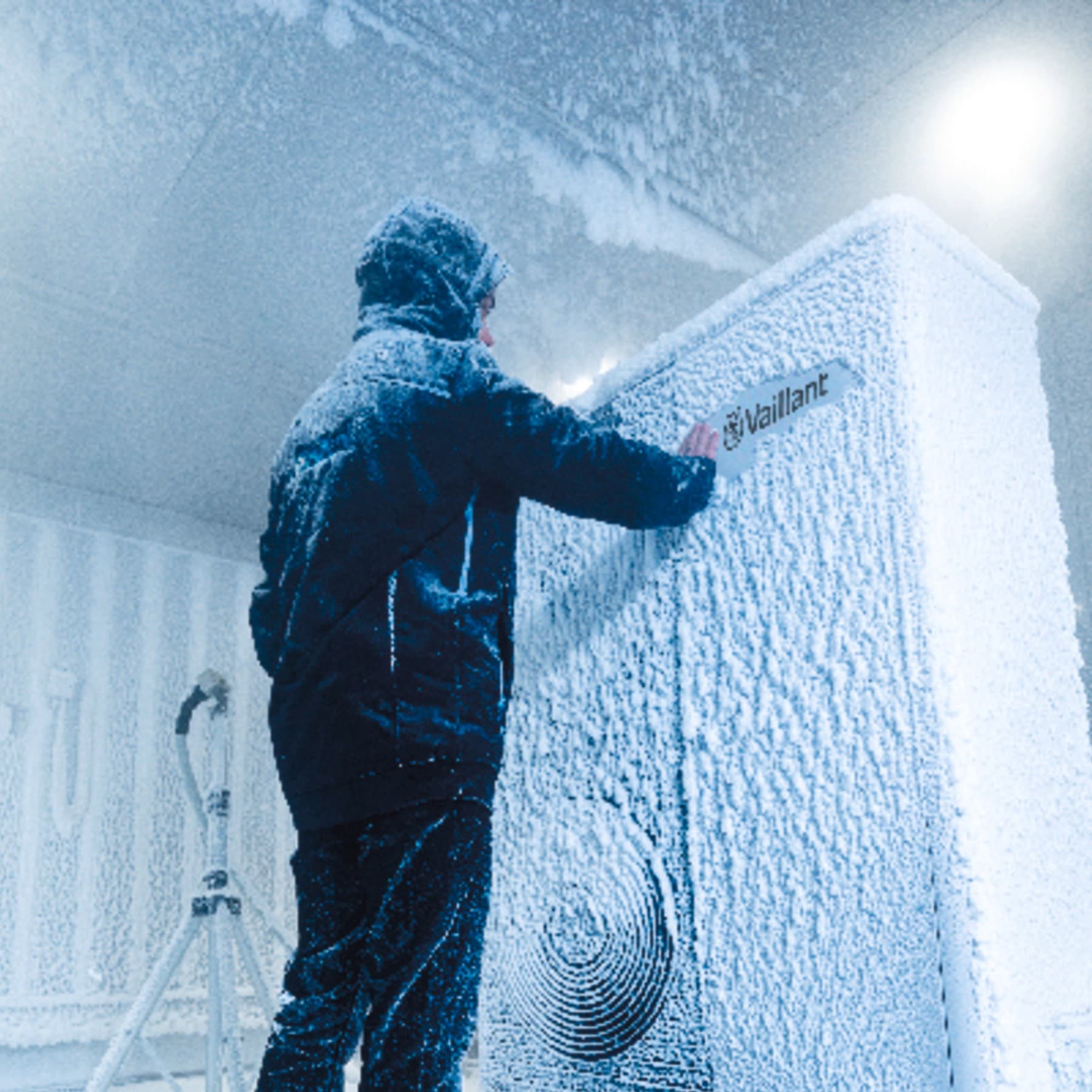 Man in winterjas voor bevroren Vaillant-apparaat