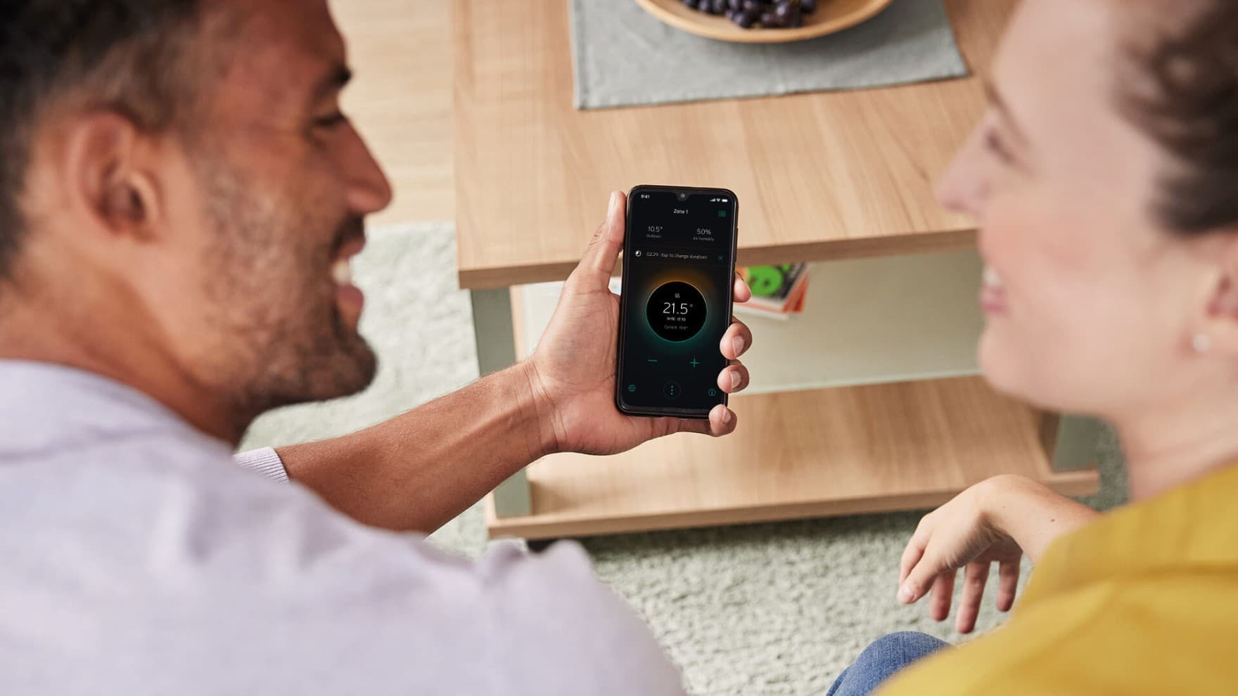 Man en vrouw kijken naar myVaillant app op de bank