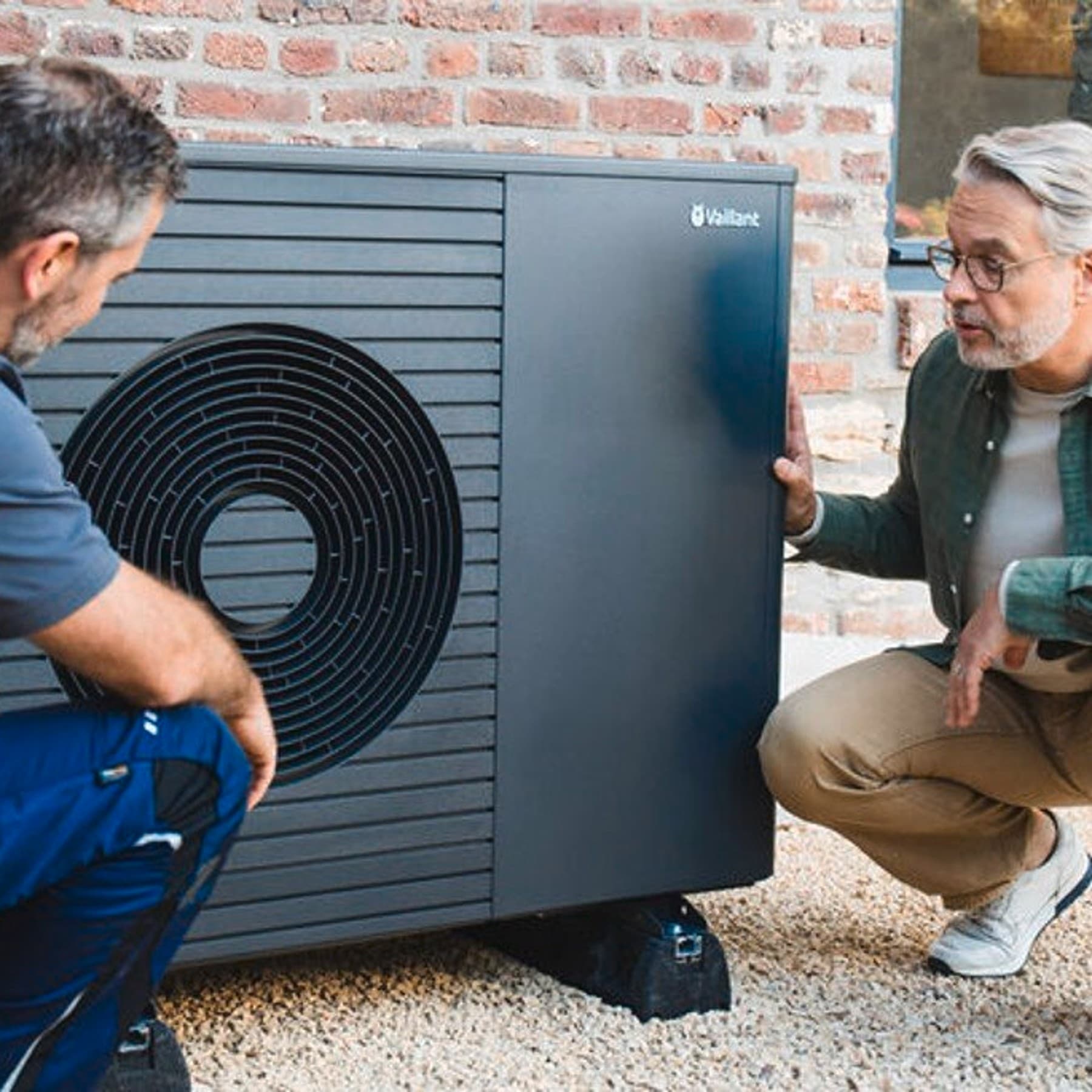 Installateur en huiseigenaar knielen voor warmtepomp