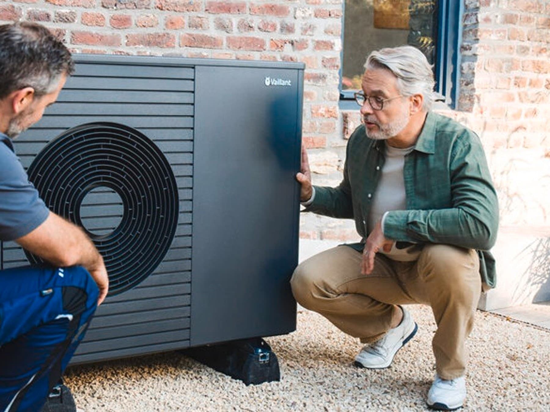 installateur en huiseigenaar naast een warmtepomp
