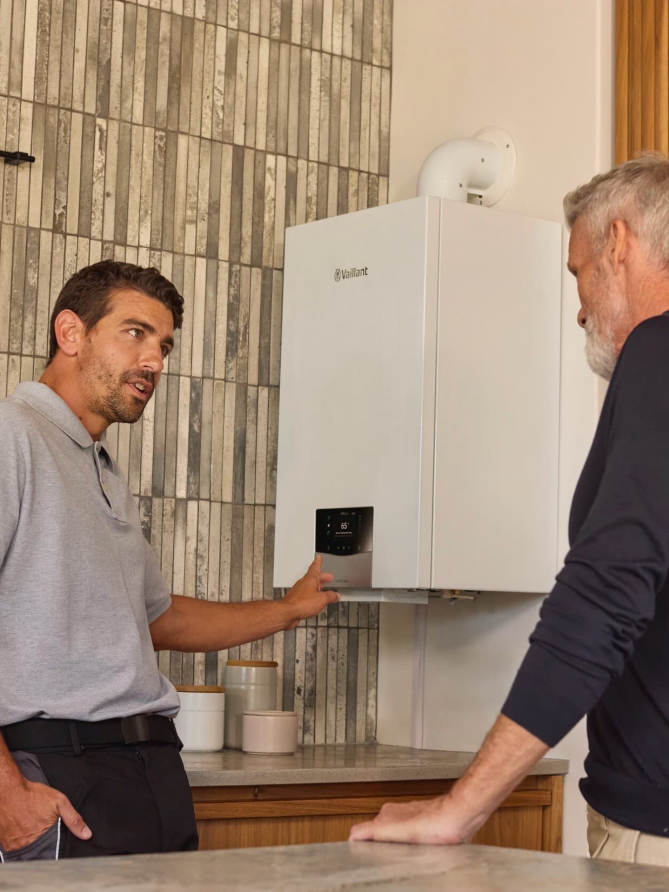 Een installateur legt een klant uit hoe een cv-ketel werkt.