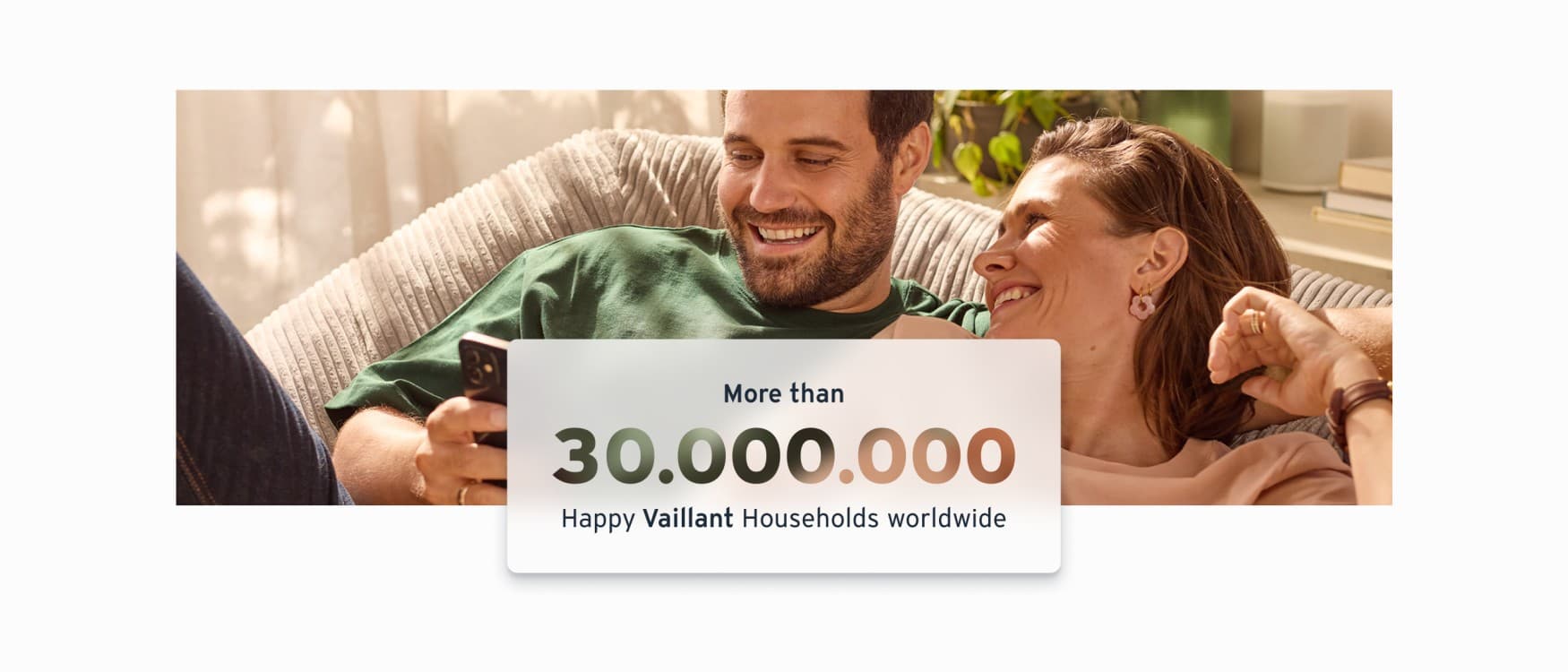 Stel zit comfortabel binnen, glimlacht en kijkt naar hun telefoon